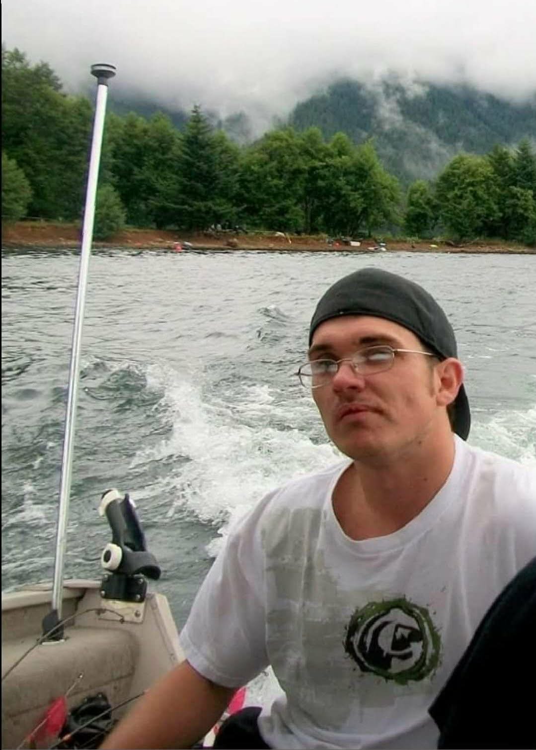 A loved one riding on a boat with mountains behind