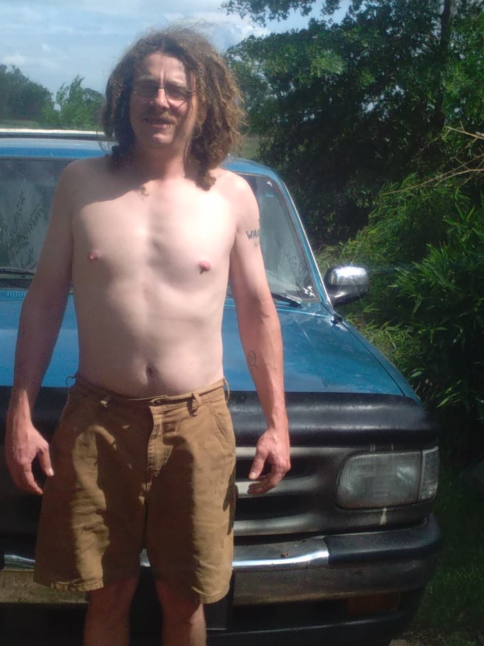 A loved one standing outside in front of a blue truck