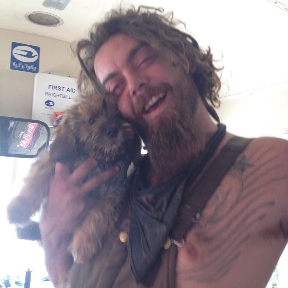 A loved one laughing while holding a small dog